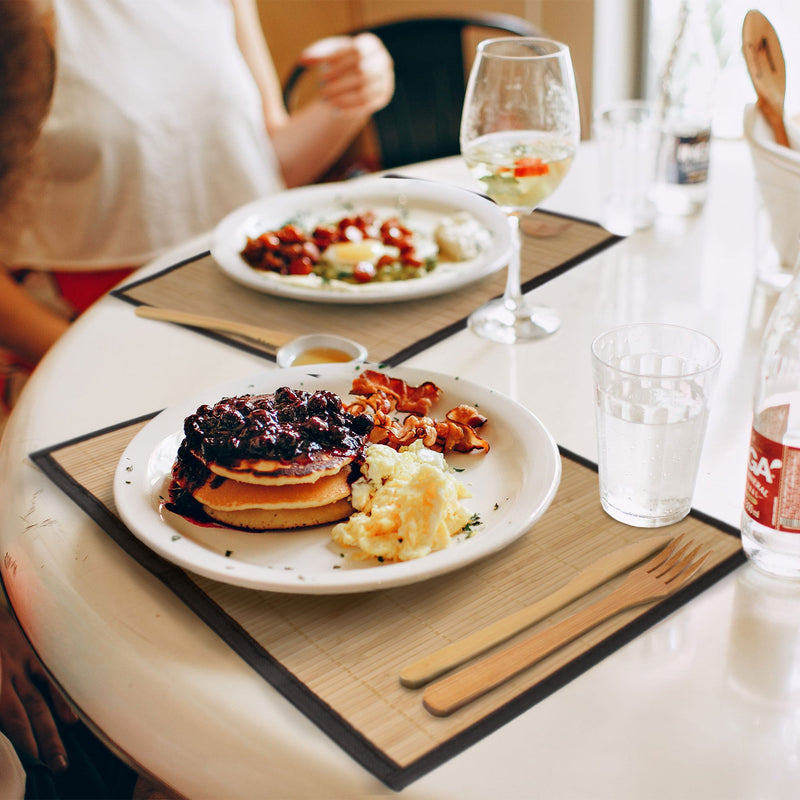 bamboo slat placemats in restaurant setting with plates of food on placemats and bamboo utensils